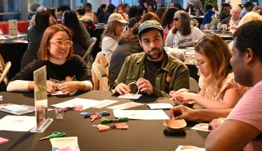 group of young people at a table talking and making art